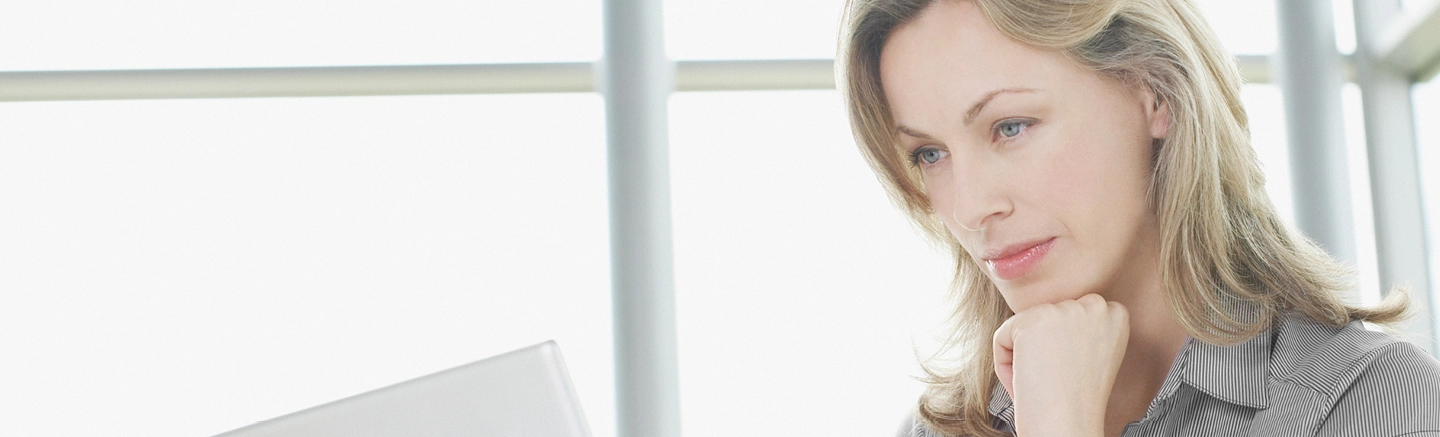 Professional sitting at a desk using a laptop in a bright modern office, supporting a guide on how to embrace change at work and adapt to thrive.