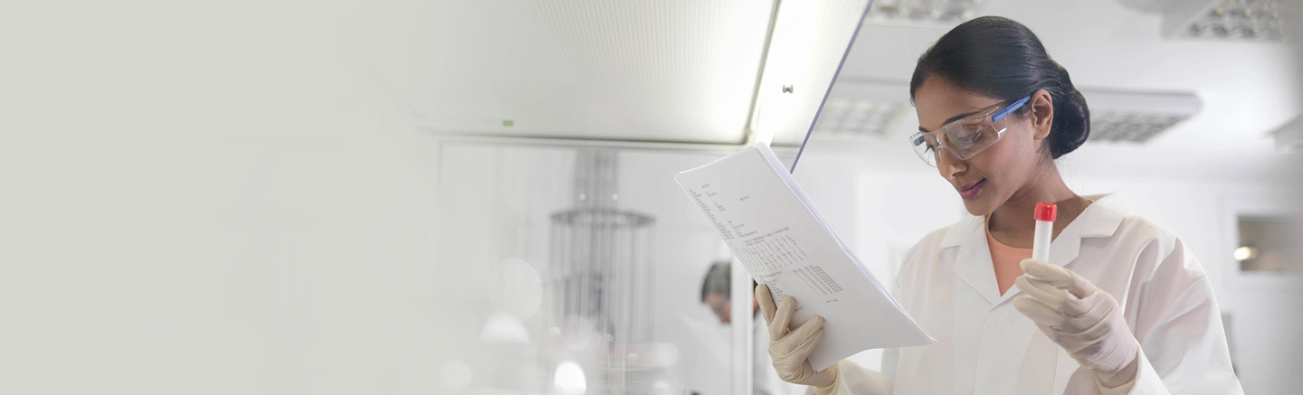 Woman wearing lab coat and holding test tube