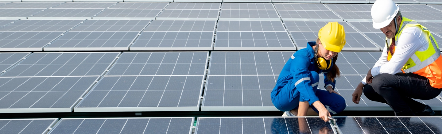 Man and woman working on solar panels