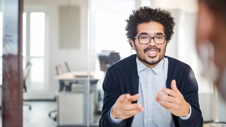 Man in office speaking with colleague