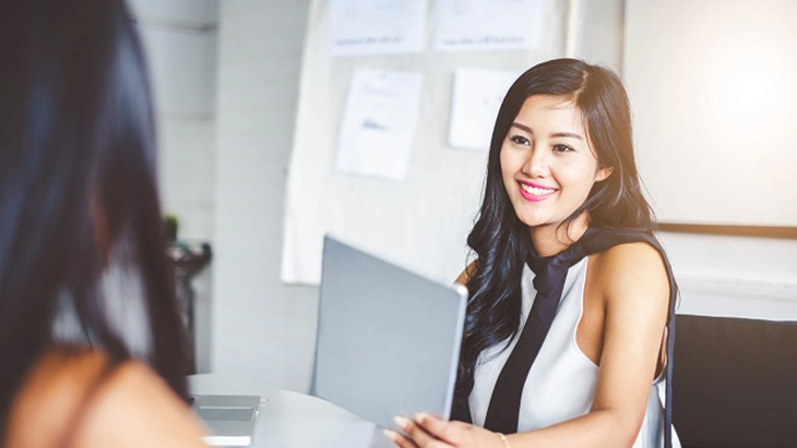 Young woman smiling in meeting.