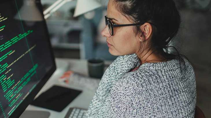 Woman at desk looking at computer screen