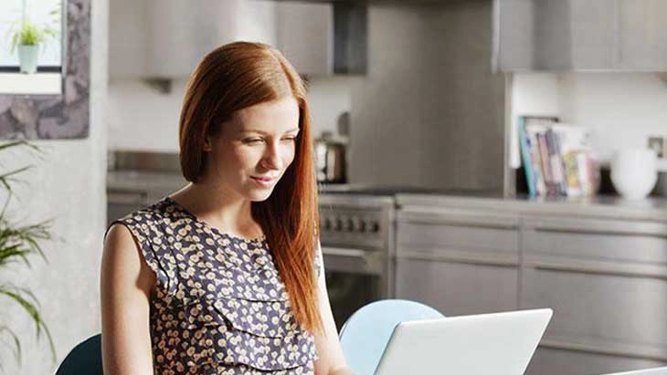 Woman smiling and working on laptop