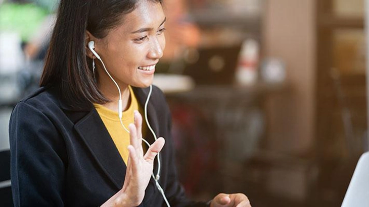 Young woman wearing earphone at computer