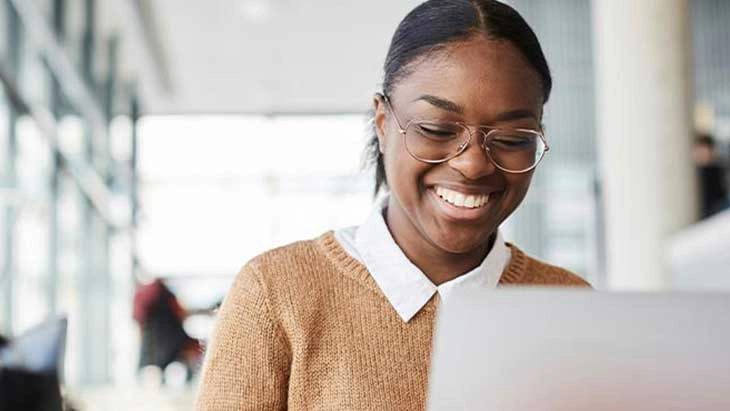 Woman working on laptop and smiling