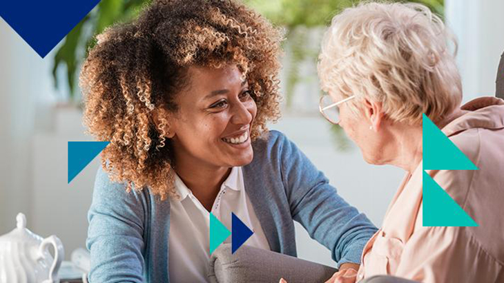 Young woman smiling and speaking with elderly woman