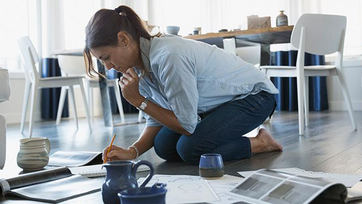 Woman kneeling on floor writing