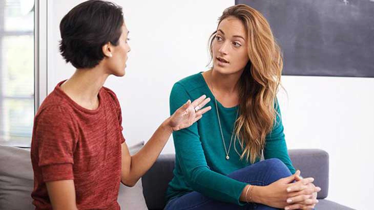 Women sitting down on couch and talking