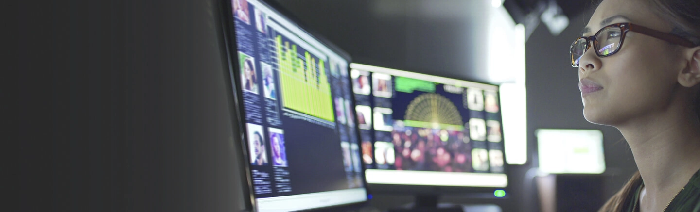 Woman working with multiple computer screens