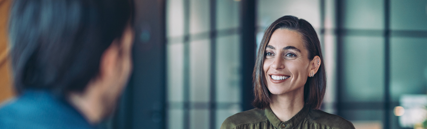 Professional interview setting with a senior candidate speaking across a table, representing executive-level interview preparation and leadership career progression