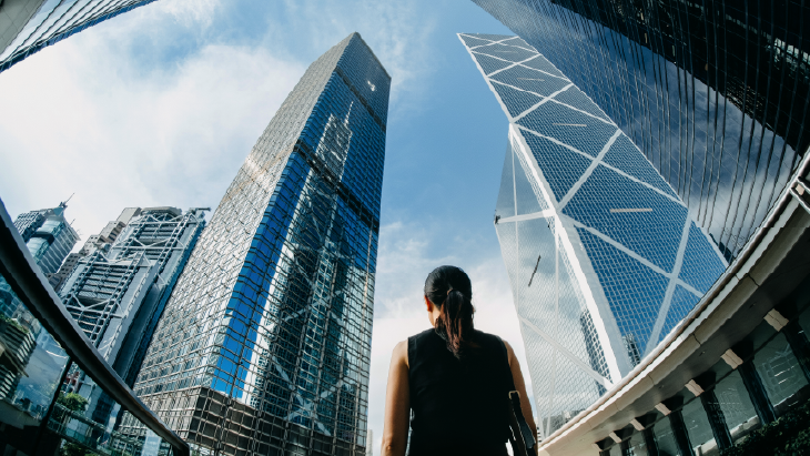 Woman walking between skyscrapers