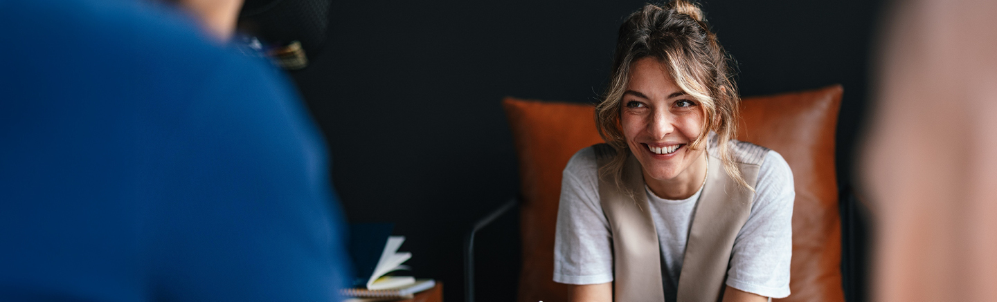 Banner for Hays Ireland Salary & Recruiting Trends 2026 guide with a person seated on a brown leather chair against a dark background.